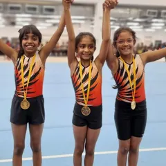 Victory is sweetest when shared. Three of my students celebrate together after winning their medals, holding hands high to acknowledge their collective success.