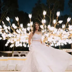 A bride twirls with joy in front of a stunning, custom-made tree of light. This unique, artistic installation served as a magical photo backdrop for her reception, creating an ethereal and unforgettable visual.