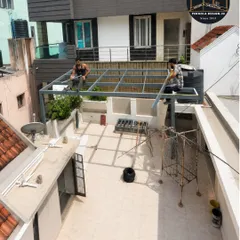 A wider angle of the work in progress. This view shows the scale of the terrace project and how the custom-fabricated pergola structure is designed to fit the specific dimensions of the space.