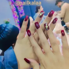 A deep, glossy maroon polish on square-shaped nails. This set is enhanced with a single accent nail featuring an intricate gold and crystal design, showing how to elevate a classic manicure.