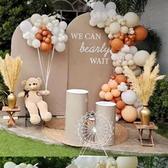 A cute and trendy "We Can Bearly Wait" theme for a baby shower. The neutral-toned balloon garland, teddy bear prop, and pampas grass create a warm and gentle boho vibe.