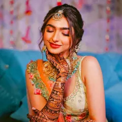 A happy bride beautifully showcasing her full-arm bridal mehandi. Seeing my clients smile is the best part of my work, and this design captures the joy of the occasion.