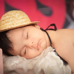 Even a boss baby needs her beauty sleep. This close-up captures the peaceful expression of a newborn amidst a fun and creative themed set.