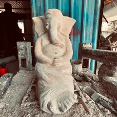 This is a Ganesha sculpture in its early, raw form. After shaping the basic structure, it is left to dry slightly before the intricate carving work begins. You can already see the gentle posture taking shape.