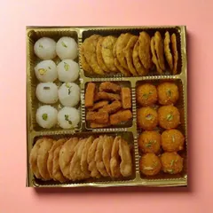 A box full of sweet and savory treats. Here you can see our motichoor ladoos and coconut ladoos alongside crispy mathri and shakkarpara. We can customize these boxes for your parties or as festive giveaways.