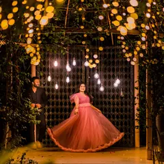 As night falls, we use the magic of light to create a truly romantic atmosphere. This shot, framed by a canopy of warm lights, shows how we can craft an intimate, dreamy portrait that feels like a scene from a movie.