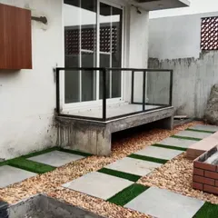 This design combines stone pavers with artificial grass and a pebble bed. It's a modern, low-maintenance solution for backyard patios and walkways.