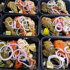 A closer look at my Tangdi Kebab Platters, portioned and packed for individual meals. Each container holds a mix of Tandoori, Malai, and Pahadi kebabs, garnished and ready to eat.