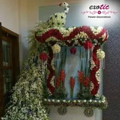 An absolutely spectacular peacock sculpture created for a Ganpati mandap. The bird's form is crafted from red and white flowers, with a magnificent tail that flows down to the floor.