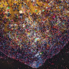 This is an abstract aerial photograph of the crowd at the Mahakumbh Mela. From this height, the mass of people becomes a canvas of color and texture, representing a single collective energy.