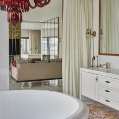 A view from the master bathroom's spa bath into the adjoining suite. The use of sliding glass doors creates an open, seamless flow, making the entire space feel like an expansive, light-filled retreat.