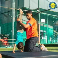 Grace, greatness, and gymnastics. A coach helps a young child perfect his handstand, demonstrating the personalized attention I provide.