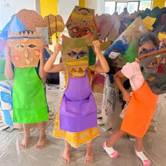 A group of children showing off the unique masks they created. This image captures the pride and fun that comes from making something with your own hands.