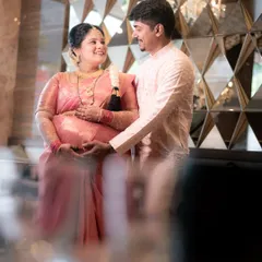 Another angle of the happy couple, framed through foreground elements to create a sense of intimacy. Their shared smile shows the joy of being surrounded by loved ones during this important milestone.