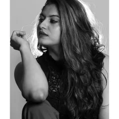A pensive, looking-away profile shot in black and white. The use of shadow and light adds depth and mood to the portrait.