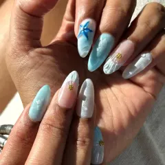 Bringing the beach to your nails! This ocean-themed set, which I wore in Goa, features 3D elements like a blue starfish, textured shells, and water droplets on a sea-blue and sandy-white base.