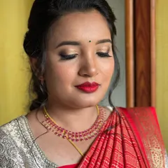 A close-up of Dhanyatha's post-wedding look. The combination of soft gold eyeshadow and a bold red lip is a timeless classic that suits her Mysore silk saree perfectly.
