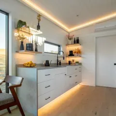 This stylish and compact kitchen demonstrates our commitment to smart design. It features a floating countertop, integrated appliances, and warm under-cabinet lighting, making it both beautiful and highly functional.