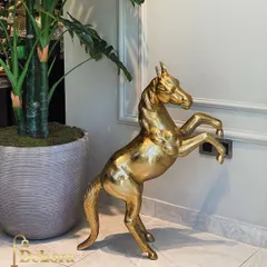 This large, freestanding brass horse sculpture makes a powerful statement in any entryway or living space. The polished gold finish and dynamic pose capture the essence of equine grace, reflecting the high level of metal artistry from our workshop.