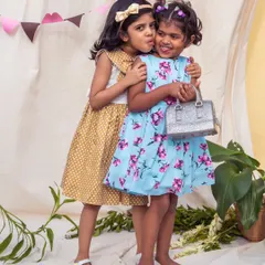 Sweet moments between friends. One wears a mustard polka dot dress while the other is in a blue floral print, showing how different styles can still complement each other beautifully.