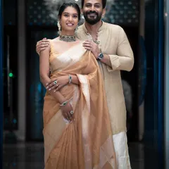 A full-length shot of the couple, showing how her modern choker and his simple, elegant attire create a perfectly coordinated look.