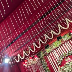 A closer look at the ceiling treatment for the Radha Ashtami event. We draped the entire ceiling in maroon fabric and adorned it with delicate strings and garlands of white flowers, creating a beautiful canopy.