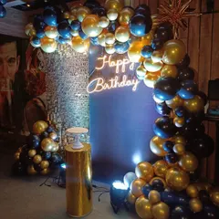 A classic and bold look for a 40th birthday. The deep blue and gold chrome balloon arch creates a dramatic entrance, perfectly complemented by a simple "Happy Birthday" neon sign.