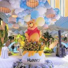 For a journey into the Hundred Acre Wood, I designed this towering Winnie the Pooh centerpiece emerging from a giant "Hunny" pot. The ceiling was transformed into a sky of blue and yellow balloons, making the entire space feel like a storybook page brought to life.