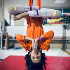 The world looks different upside down. This young yogi smiles while holding an inverted lotus pose, a fun and beneficial posture for all ages.