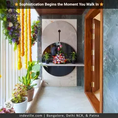 A home's story begins at the entrance. I designed this entryway with a modern marble and mirror feature, complemented by lush potted plants and traditional flower garlands for a sophisticated first impression.