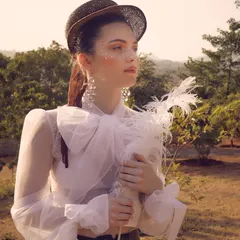 For Starchthelabel's 'White Rose' collection, I developed a romantic, vintage-inspired creative concept. This portrait captures the poetic and dreamy mood, with delicate styling details like the sheer bow blouse, feathered accessory, and soft lighting to tell a story of timeless elegance.