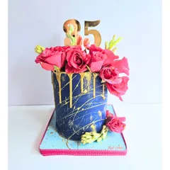 A bold and beautiful cake for an 85th birthday. The deep blue frosting with a dramatic gold drip and fresh pink roses creates a striking contrast. It’s a sophisticated design for celebrating a major milestone in style.