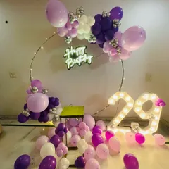Personalize your birthday decor with light-up marquee numbers, like the '29' featured here. We integrated them seamlessly with a purple and pink partial balloon ring and a "Happy Birthday" neon sign for a cohesive and custom look.