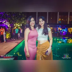 Guests posing by the beautifully lit pool at Taj MG Road. The venue's ambiance perfectly complements the music for a classy evening.
