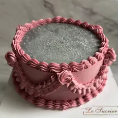 A close-up of the intricate piping on a vintage-style cake. The detailed ruffles and rosettes are crafted from pink buttercream for a soft, romantic look.