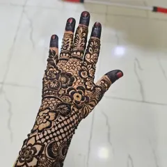 A classic "sider" mehndi design with a full palm and wrist pattern. The combination of net (jaali) work and floral motifs is a timeless favorite.