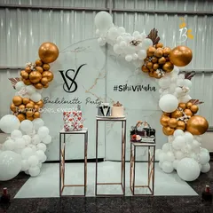 We design stylish bachelorette parties that are perfect for the gram. This setup features a trendy marble-print backdrop, a custom balloon arrangement in gold and white, and personalized signage with the couple's hashtag.