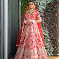 A full portrait of bridal elegance. The classic red lehenga is a statement of tradition and love, and I ensure the makeup complements it perfectly, with a focus on radiant skin and a confident smile.