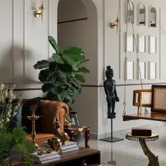 In my 'Kaalam' project, every corner tells a story. Here, a traditional bronze statue and a wooden swing with cane details are set against a backdrop of clean, modern wall molding. It’s a space that celebrates heritage with a contemporary spirit.