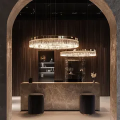 This installation features two grand, crystal-ring chandeliers of different sizes, creating a dynamic, layered effect. The design provides brilliant illumination over the reception desk while adding a touch of modern glamour.