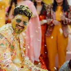 The groom, all smiles and covered in petals, enjoying every moment of his fun-filled Haldi celebration.