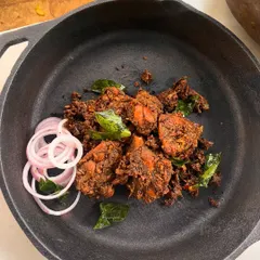 My Kovalam Smoky Roasted Chicken, also known as Chicken Chuttathu. The chicken is marinated in traditional stone-ground spices and then smoke-cooked for a robust, spicy flavor that is absolutely drool-worthy.