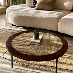 Another angle of the rattan and wood coffee table, showing how it complements a light-coloured bouclé sofa.