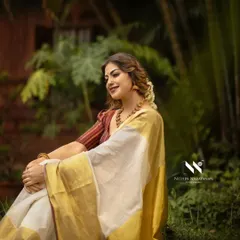 A serene moment captured during the Onam shoot with Anusree. The soft drape of the saree complements the natural, peaceful environment.