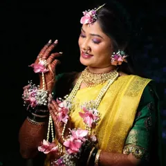 A full view of this bride's Haldi attire. The yellow saree and green blouse are beautifully accessorized with custom floral jewelry for her hands, ears, and hair.