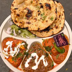 My special thali offers a taste of everything. It includes Dal Makhani, Shahi Paneer, another seasonal vegetable, and hot Butter Naan, all served together on one plate.