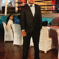 Dressed for an event with the boxing ring in the background. Behind every great fight is a team of dedicated officials, and I'm proud to be one of them.