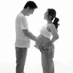 The first chapter of a lifelong story. This black and white photo captures the pure, unfiltered joy and laughter between a couple expecting their child.