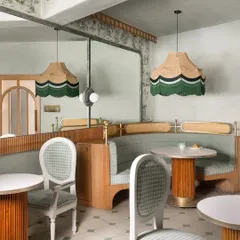An overall view of the seating arrangement at 11 Grams Cafe. We designed a mix of curved booths and freestanding tables to create different dining experiences, from intimate corners to more open seating areas.