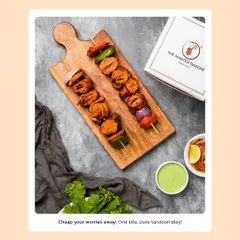 Our Tandoori Soya Chaap skewers, beautifully arranged on a wooden board. The chaap is tender on the inside with a perfectly spiced and charred exterior, served with grilled onions and peppers.